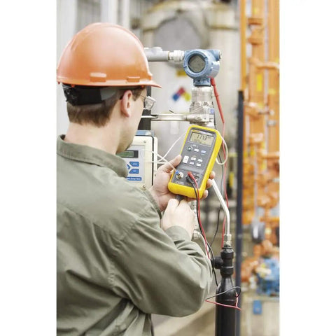 Technician using Slick One Hand Electric Pressure Calibrator for precision pressure checks in an industrial setting.