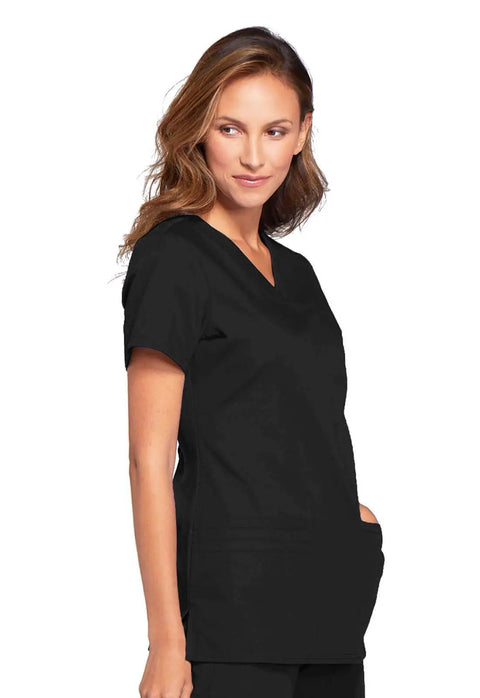 Woman wearing Women's Slim Fit V-Neck Scrub Top With 3 Pockets And Instrument Loop, Fade-Resistant Fabric, Black, Size M, side view.
