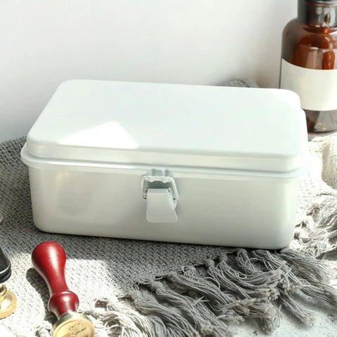 Heavy Duty Vintage White Metal Toolbox Featuring A Tight Snap Shut Locking Latch Tin Storage Case For Everyday Gear And Art Supplies Classic Secure Organizer Trunk on a textured surface.