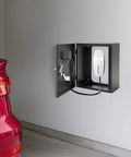 Badass Heavy Duty Wall Mount EV Charger Lock Box With Dial Combo Padlock And Slick Black Cold Rolled Steel Anti Theft Security Case For 19 Inch Charging Gear mounted on wall with charging plug visible.
