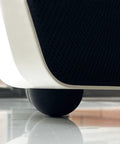 Close-up of 1.25 Inch Speaker Isolation Pads With Adhesive Rubber Feet Four Pack under subwoofer, showing vibration damping features.