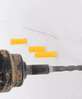 Drill in action near yellow plastic expansion plugs from Yellow Plastic Wall Plugs Kit With Self Drilling Anchors 200 Piece Set For Hollow Walls