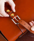Hands securing Two Piece Titanium Alloy Binding Screws For Heavy Duty Document Sorting And Hella Durable Scrapbook Fasteners No Drama Snap Lock Photo Album Posts Prime Picks on a leather bag strap.