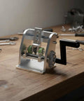 Portable Edge Tape Slitter And Edge Banding Cutter for woodworkers on a workbench, 80mm trim tool with manual crank handle.