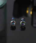 Premium 5A Cubic Zirconia Screw Back Stud Earrings For Men And Women on a reflective surface, showcasing their dazzling colors.