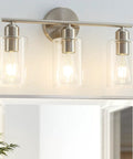 Three Light Bathroom Vanity Light Fixture In Brushed Nickel With Clear Glass Shades Over Mirror Wall Sconce No Fuss Easy To Install