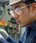 Man wearing Built Like A Tank Z87 Plus Safety Reading Glasses With Wraparound UV400 side shields in a work environment.