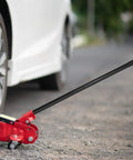 3 Ton Floor Jack Handle Replacement Built Tough With No Slip Rubber Grip for Hydraulic Jacks in use beside a parked car