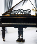 Vintage Brass Caster Set Offering Heavy Duty Swivel Furniture Wheels on a black grand piano in a bright room.