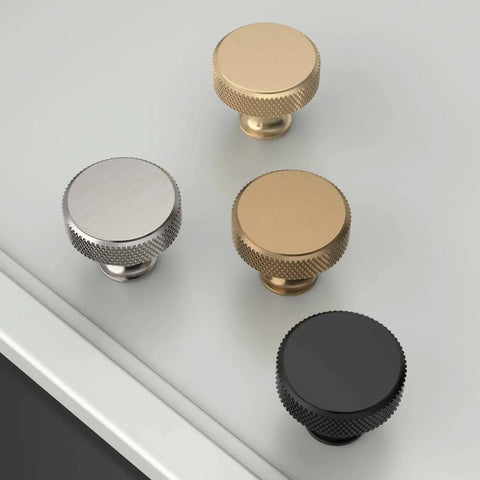Four knurled cabinet knobs in gold, silver, bronze, and black on a table surface, 10 Pack Gold Knurled Cabinet Knobs For Drawers, Dressers, Cupboards And Wardrobes, Sleek Knurled Handles With Easy Install Mounting, Durable Brass Construction, Modern Kitchen And Bedroom Hardware, Model ZH0036