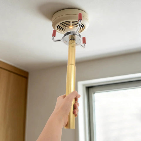 Professional Smoke Transducer Removal Tool With Extended Steel Rod And Secure Jaw Grip being used to replace ceiling smoke sensor.
