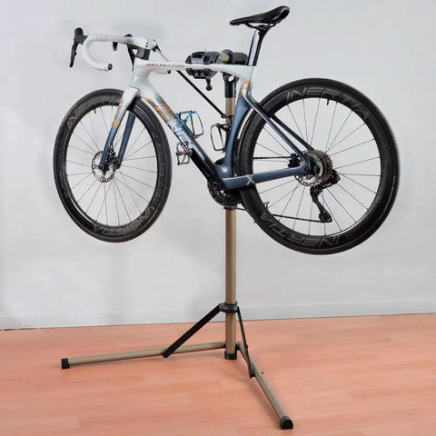 Adjustable Height Bike Repair Stand With Foldable Design For Home And Shop, 360 Degree Rotating Clamp, Anti Slip Feet On Triangular Base, 65 Lbs Load Capacity holding a road bike