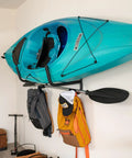 Heavy Duty Swivel Kayak Rack For Garage Walls That Folds Flat saves floor space, securely holding a blue kayak on wall.