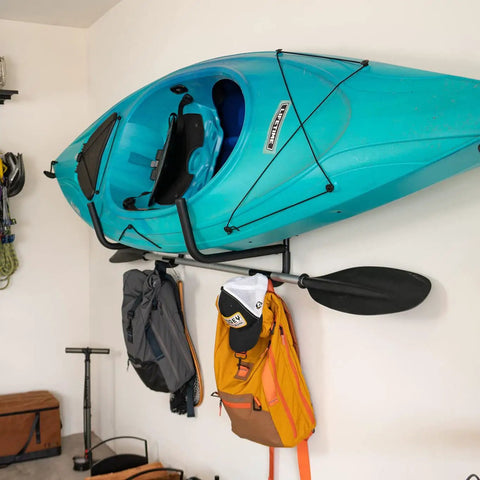 Heavy Duty Swivel Kayak Rack For Garage Walls That Folds Flat saves floor space, securely holding a blue kayak on wall.