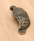 Prime Sleek Distressed Antique Brass Seashell Cabinet Pulls 8 Piece Set Embossed Furniture Cup Handles close-up detail on wooden surface.