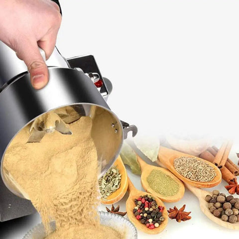 Beast Mode Heavy Duty 2000g Electric Grain Grinder Mill pouring beige powder near spices and herbs on wooden spoons