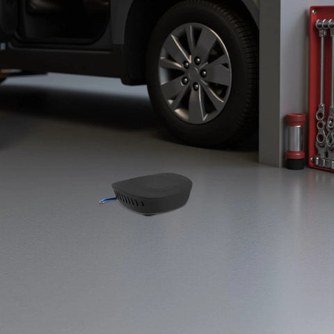 Automatic Fire Suppression System And Vehicle Fire Extinguisher With Self Activating Aerosol Mechanism For Cars Trucks And Vans, compact black unit on garage floor.
