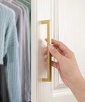 Top Shelf 10 Pack Brushed Gold Cabinet Pulls 5 Inch Square Bar Drawer Handles on cabinet door, solid metal hardware in use.