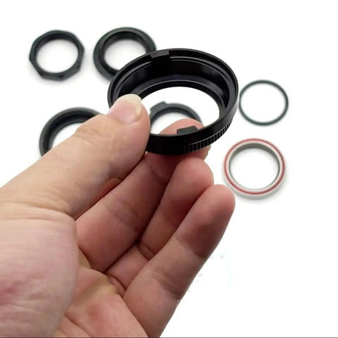 Hand holding a part from Top Shelf Heavy Duty Steering Head Bearing Set For Y Series Electric Scooters Y6s Y8s Complete Ball Bearing Kit.