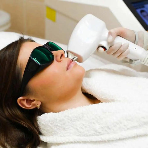 Woman wearing Professional IPL Laser Safety Glasses for hair removal during a treatment, using a laser device.