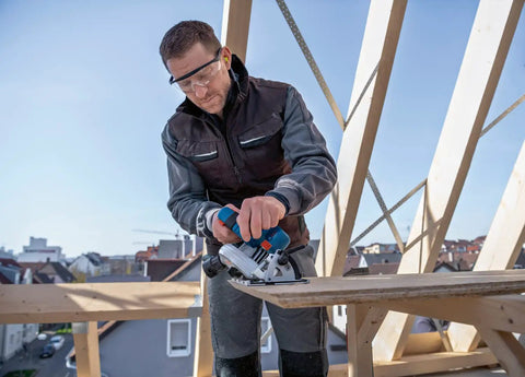 Badass 18V Cordless Brushless Circular Saw With Slick Six Point Five Inch Blade in use on lumber at a construction site.