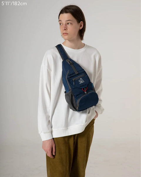 Person wearing a blue Packable Small Crossbody Sling Backpack For Travel And Hiking Ultralight Water Resistant Daypack on chest