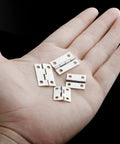 Rock Solid 70 Pcs Mini Hinge Set With 300 Tiny Screws Includes Both 24 X 16 Mm And 18 X 15 Mm Sizes showing durable silver folding butt hinges in hand.