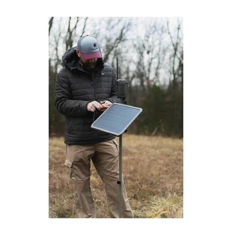 Person using All Day Juice External 10 Inch Solar Panel With Integrated 10000 Mah Battery Pack For Trail Cameras outdoors.