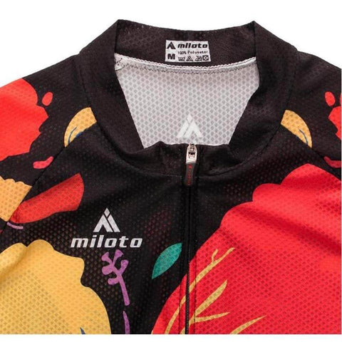 Close-up of a colorful cycling jersey with red, yellow, and black floral patterns and a zippered front.