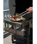 Using tongs from the Stainless Steel BBQ Grill Tools Set With Ergonomic Wood Handles to serve food at outdoor barbecue
