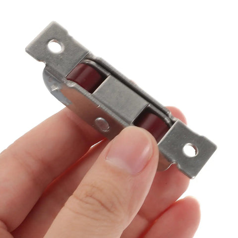 Hand holding a stainless steel sliding window sash pulley with double roller design, part of Top Shelf Four Pack.
