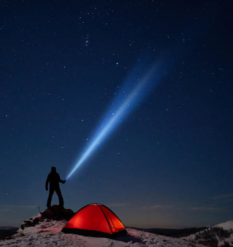 Person using 3 Cell D LED Flashlight With Adjustable Beam And Multiple Modes Ultra Long Battery Life For Home Camping And Emergencies Water Resistant Built Tough For Tactical And Everyday Use Gray near a tent in snow under stars.