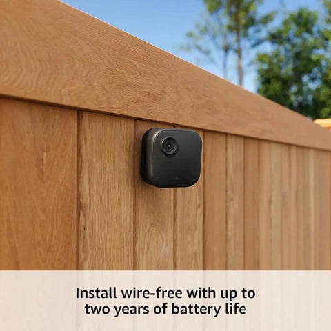Outdoor 4 Wireless Smart Security Camera System With 1080p HD Day And Night Vision Two Way Talk Two Year Battery Life Five Camera Bundle installed on a wooden fence