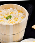 Premium Handcrafted Wood Steamed Rice Bucket With Lid, Round Beige Cask filled with rice and corn, placed on black surface.