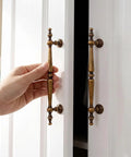Solid Antique Brass Cabinet Pulls 5 Inch Drawer Handles 5 Pack vintage zinc alloy, hand opening cupboard knobs on white cabinet.