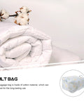 Level Up Your Storage With This Heavy Duty Cotton Quilt Bag Featuring Secure Zipper Seals And Sturdy Handles To Hold Blankets Linens And Seasonal Gear Folds Flat For Easy Shelving Reduces Clutter Instantly Makes Packing Relocations A Breeze. White rolled quilt resting beside cotton branch, highlighting material and design.