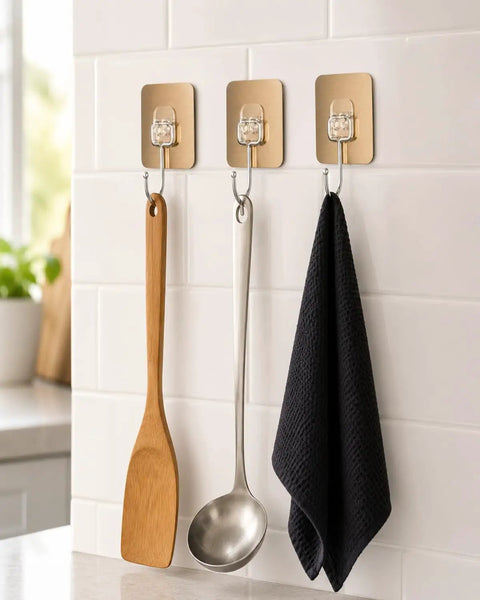 Six Pack Tough Grip Adhesive Wall Hooks Offering No Sweat No Drill Install slick gold square plate with clear hooks holding kitchen utensils.