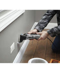 Person using Pro Grade Corded Oscillating Multi Tool Kit 120V 3.5 Amp Power, Reconditioned for precise wall cutting.