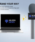 Super Smooth Grip Handheld Adapter For Wireless Lavalier Mics In A Solid Twin Pack Setup Compatible With Dji Rode And Hollyland Gear, with personalized mic flag next to laptop.