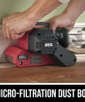 Hands using Beast 6 Amp Belt Sander With Pressure Control for smooth wood finishes, showing auto track and micro filtration dust system.