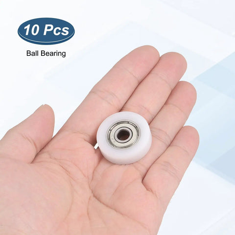 10 Piece Nylon Track Rollers 6Mm Bore 28Mm OD Heavy Duty Linear Glides in a hand for sliding hardware use.