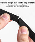 Close-up of hands cutting black Six Point Five Foot Two Roll Adjustable Cable Ties Reusable Hook and Loop Fastening for Cable Organizing.
