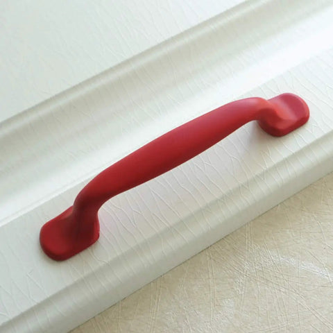 Hella Durable Zinc Alloy Drawer Knobs And Kitchen Cabinet Handles Built Tough For Daily Use Featuring Easy Grip Pulls For Dressers And Kids Furniture Hardware In Totally Dope Colors. Red zinc alloy handle on textured white cabinet.