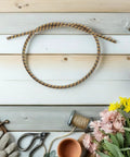 Gardening tools and flowers on wooden background with coiled rope