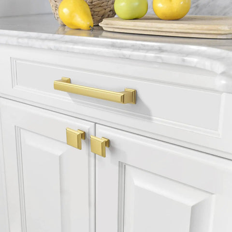 Premium Brushed Gold Drawer Pulls 10 Pack 5 Inch Cabinet Handles on white cabinets with fruit on countertop.