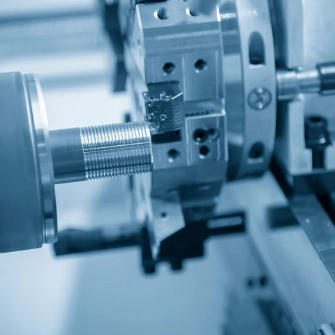 Fully threaded M6 x 50mm stainless steel rod mounted in a CNC lathe for machining.