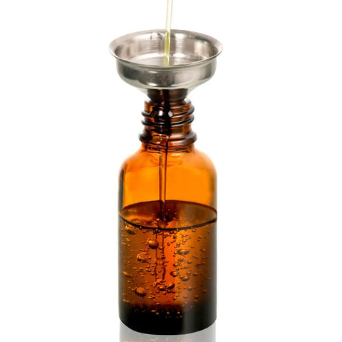 Pouring liquid into a Super Durable 24 Pack 1 Oz Amber Glass Eye Dropper Bottle with stainless funnel.