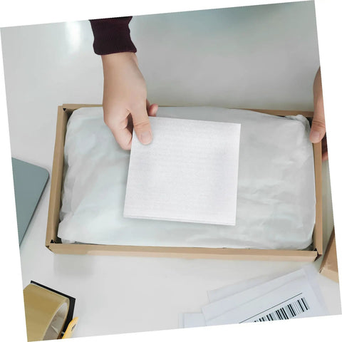 Hand placing 100 Pack Epe Foam Pouches For Shipping Fragile Electronics into a shipping box for added protection.