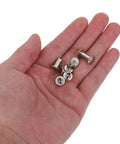 Hand holding assorted metal screw rivets from Badass Durable 110 Pack Leathercraft Screw Rivets And Gnarly Heavy Duty Metal Fasteners.