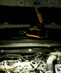 Cordless LED Work Light Compatible With Dewalt And Milwaukee 18V 20V Batteries illuminating car engine with magnetic base attachment.
